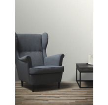 Woonkamer met fauteuil en bijzettafel met kaarsen