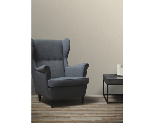 Woonkamer met lichtbeige textielbehang, fauteuil en bijzettafel