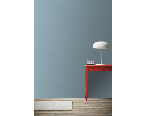 Scene met rode tafel, witte lamp en klok tegen een muur