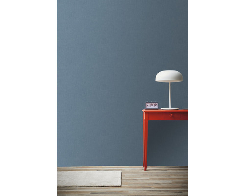 Lichtgekleurd tapijt, blauwe achtergrond, rode tafel met klok en lamp