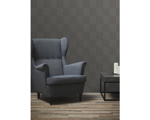 Woonkamer met oorfauteuil, salontafel en patroonbehang