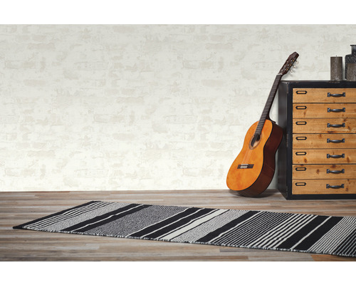 Kamer scène met een gestreepte vloermat, gitaar en ladekast