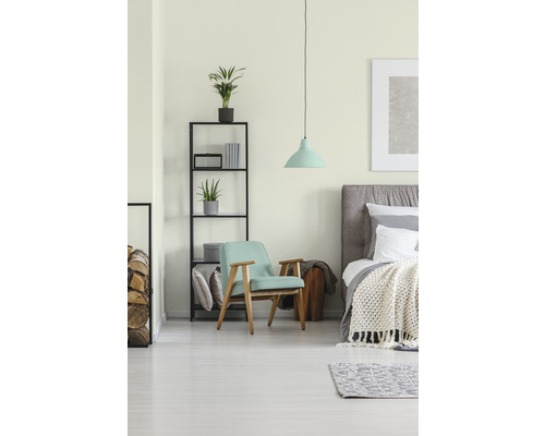 Lichte slaapkamer met bed, fauteuil, rek en hanglamp