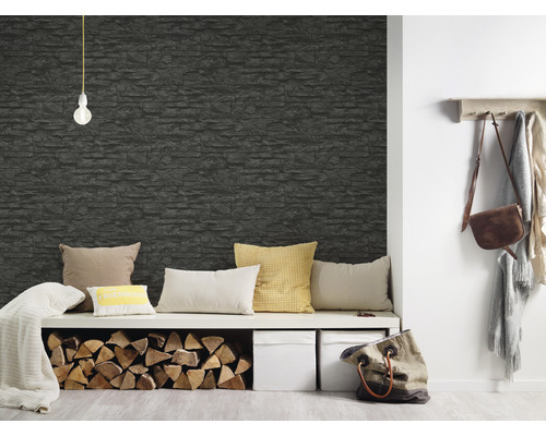 Woonkamer met een stenen wanddecoratie, zitmeubel, kussens en brandhout.