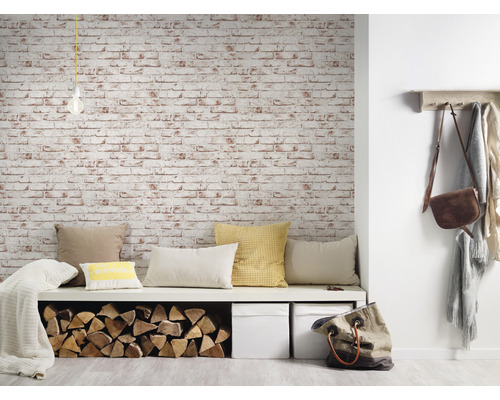 Woonkamer met bank, kussens, stapel hout, opbergdozen en bakstenen behang