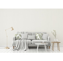 Woonkamer met bank, kussens, tafel en vloerlamp