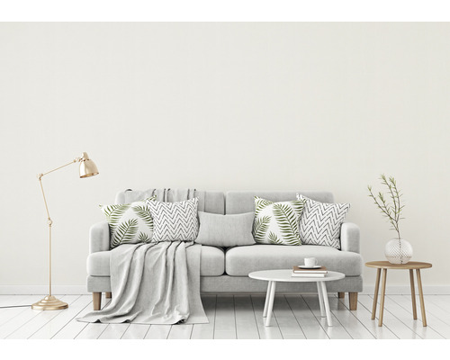 Woonkamer met bank, kussens, tafel en vloerlamp