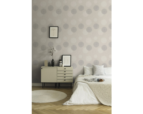 Slaapkamer met commode, bed en behang met cirkelmotief