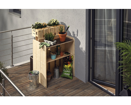 Houten plantentafel met bloembakken en tuingereedschap op een balkon