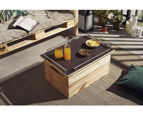 Buitenruimte met bank van pallets en tafel van houten kisten, gedecoreerd met drankjes en snacks