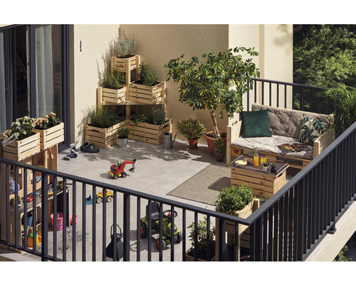 Balkon met planten in houten kisten, houten pallet als zitgelegenheid en kinderspeelgoed