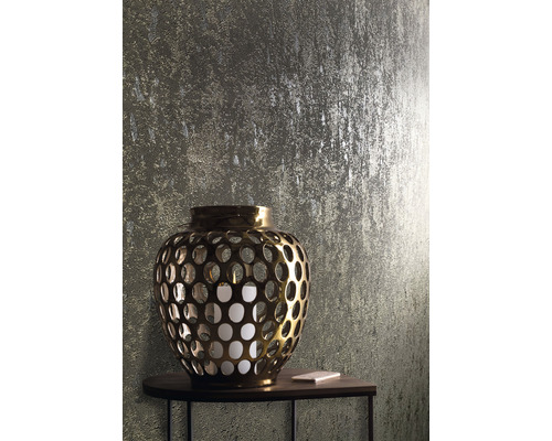 Gouden lantaarn met kaars op een tafel voor een gestructureerde wand