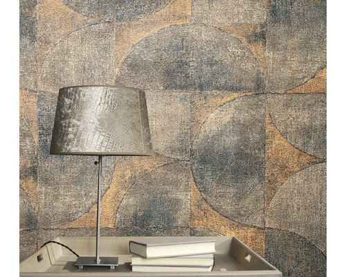 Close-up van een muur met geometrisch behangpatroon en een lamp op een tafel