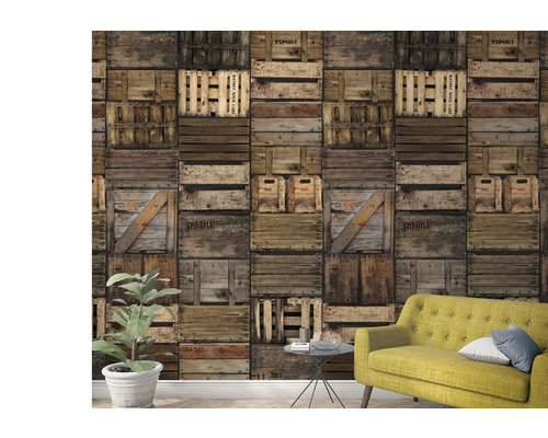 Woonkamer met behang in een ontwerp van op elkaar gestapelde houten kisten en een gele bank.