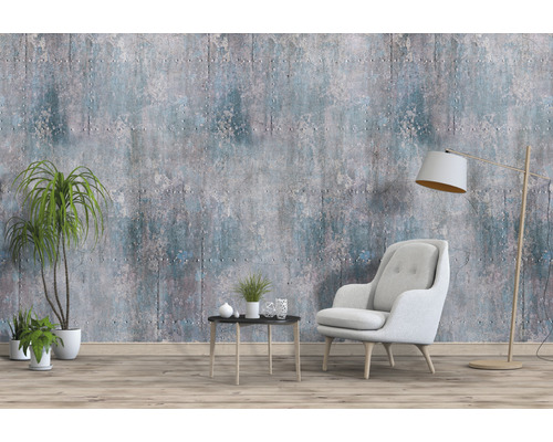 Woonkamer met fauteuil, staande lamp, tafel, kamerplanten en behang in betonlook.