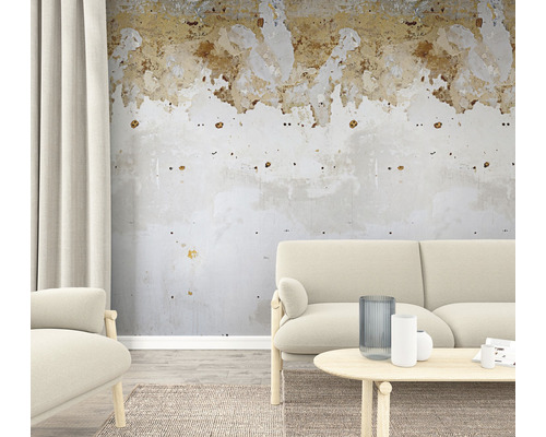 Woonkamer met bank, fauteuil, tafel en beschadigde muur