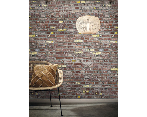 Decoratieve scène met een bakstenen muur, een rotan stoel met kussen en een hanglamp