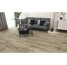 Woonkamer met lichte houten vloer, bank en salontafels.