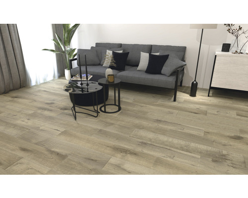 Woonkamer met lichte houten vloer, bank en salontafels.