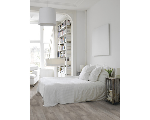 Lichte slaapkamer met tweepersoonsbed, boekenkast en houten vloer