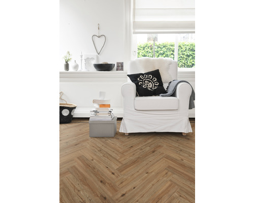 Woonkamer met visgraatparket, fauteuil en decoratieartikelen