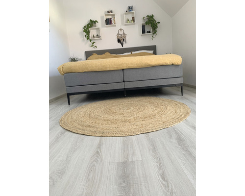 Slaapkamer met bed, wandplanken en rond vloerkleed