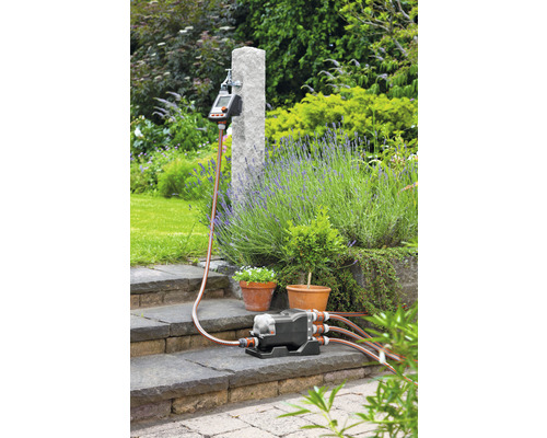 Irrigatiesysteem met verdeler, irrigatiecomputer en tuinslang buitenshuis