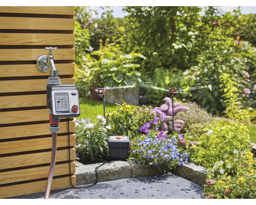 Tuinscene met waterkraan, irrigatiebesturing en gazonsproeier
