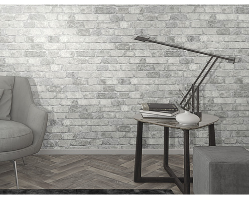 Lichte kamer met fauteuil, tafellamp en bakstenen behang