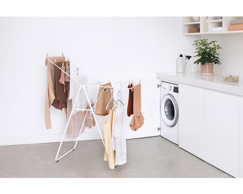 Metalen wasrek met wasgoed in een lichte kamer