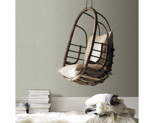 Hangstoel van rotan met kussens in een lichte ruimte