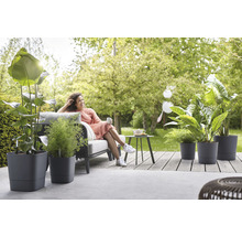 Vrouw ontspant in de tuin met planten in plantenbakken op het terras