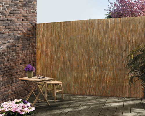 Buitenscène met een tafel, kruk en privacyscherm van natuurlijke materialen