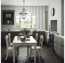 Klassieke keuken met eettafel, stoelen, hanglamp en keukenkasten.