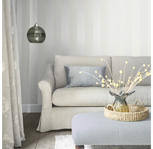 Woonkamer met bank, kussens, lamp en decoratieve artikelen