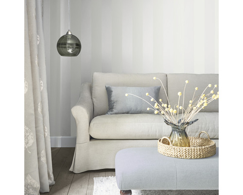 Woonkamer met bank, kussens, lamp en decoratieve artikelen