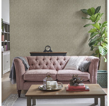 Woonkamer met patroonbehang, bank, salontafel en decoraties