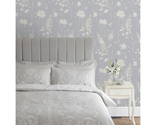 Slaapkamer met bed, nachtkastje en bloemenbehang