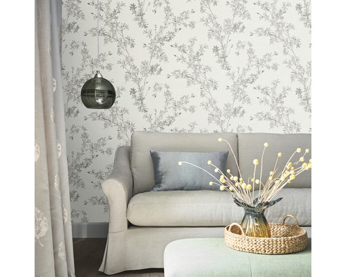 Woonkamer met bank, lamp en bloemenbehang