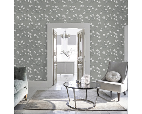 Woonkamer met grijs bloemenbehang, fauteuil en tafel