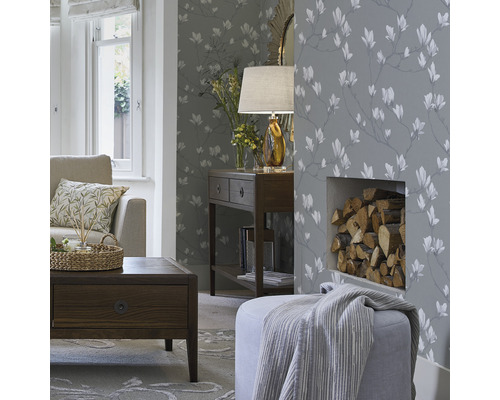 Woonkamer met patroonbehang, bank, tafel en brandhout