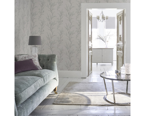 Woonkamer met bank, vloerkleed, tafel en wandbehang met plantenmotief