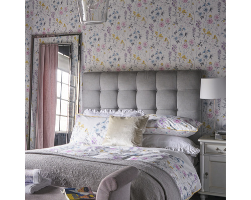 Lichte slaapkamer met bloemenbehang, gestoffeerd hoofdeinde en spiegel