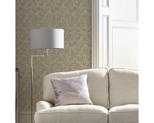 Woonkamer met bank, staande lamp en behang met bladerpatroon