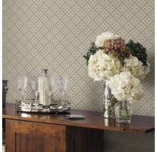 Detailopname van een beige, patroonbehang met bloemen, glazen en drankjes op een tafel