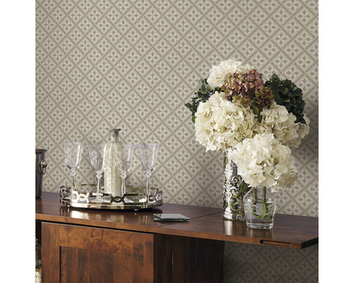 Detailopname van een beige, patroonbehang met bloemen, glazen en drankjes op een tafel