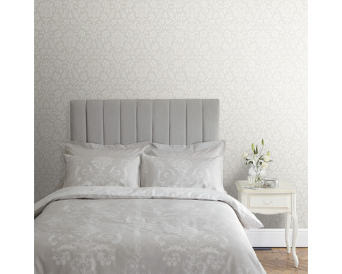 Slaapkamer met bloemenbehang, bed en nachtkastje