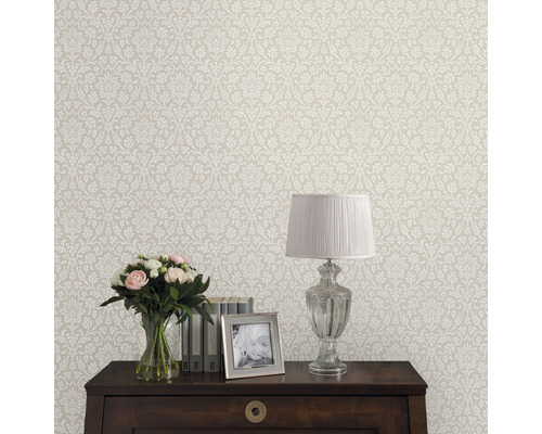 Behang met bloemmotief in interieur met tafel, lamp, bloemen en fotolijst