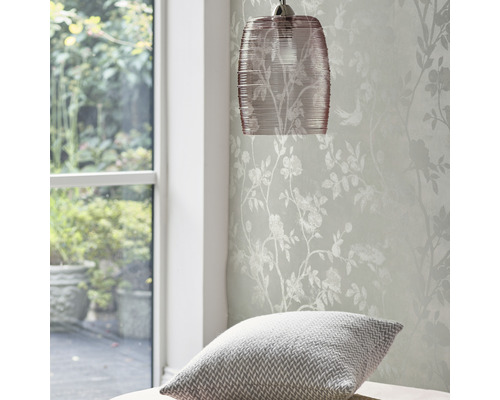 Hanglamp en behang met bloemmotief in een heldere kamer.