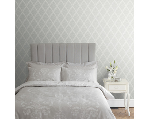 Slaapkamer met bed, nachtkastje en patroonbehang